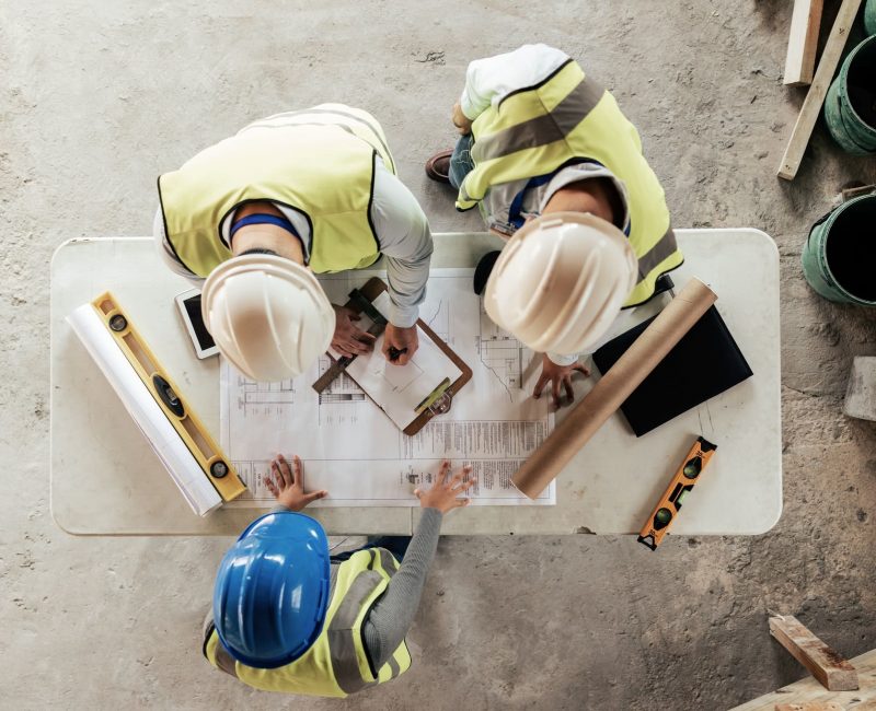 Architect, engineer and teamwork with blueprint from above on a building or contractor project. Bui Architect, engineer and teamwork with blueprint from above on a building or contractor project. Bui